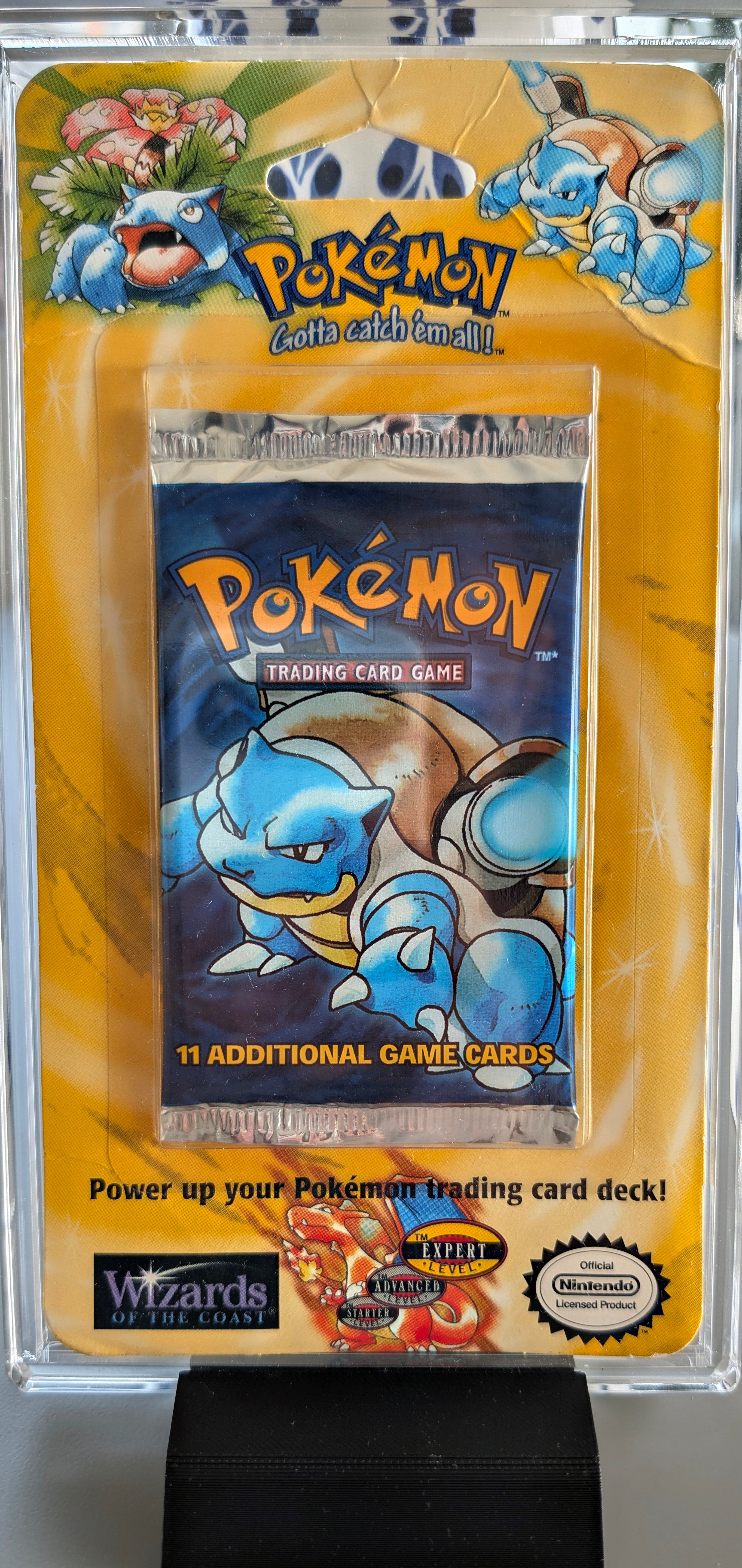 Front and back of a factory-sealed, unweighable vintage 1999 Pokemon TCG Base Set Blister Pack featuring Blastoise artwork and an original FAO Schwarz price tag.