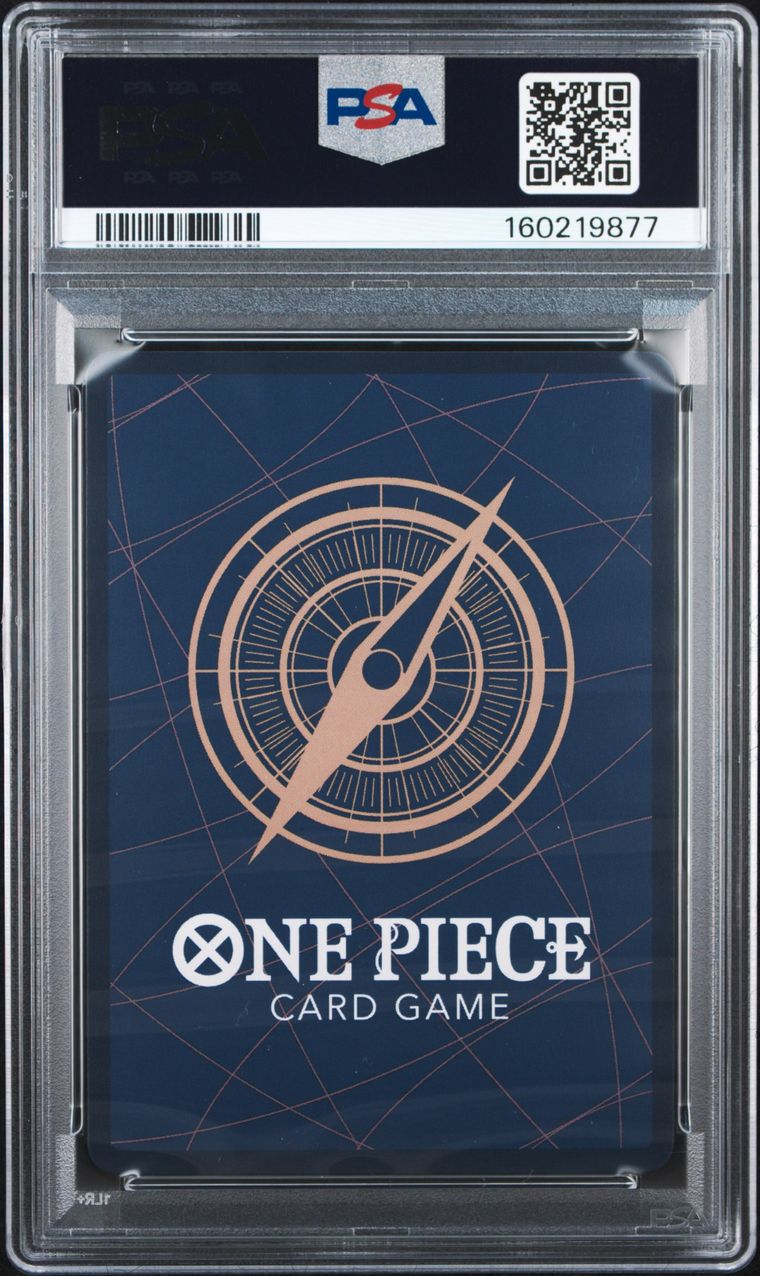 PSA graded One Piece Card Game deck box inside a clear plastic grading case, with a dark blue box featuring a compass design and PSA branding at the top.